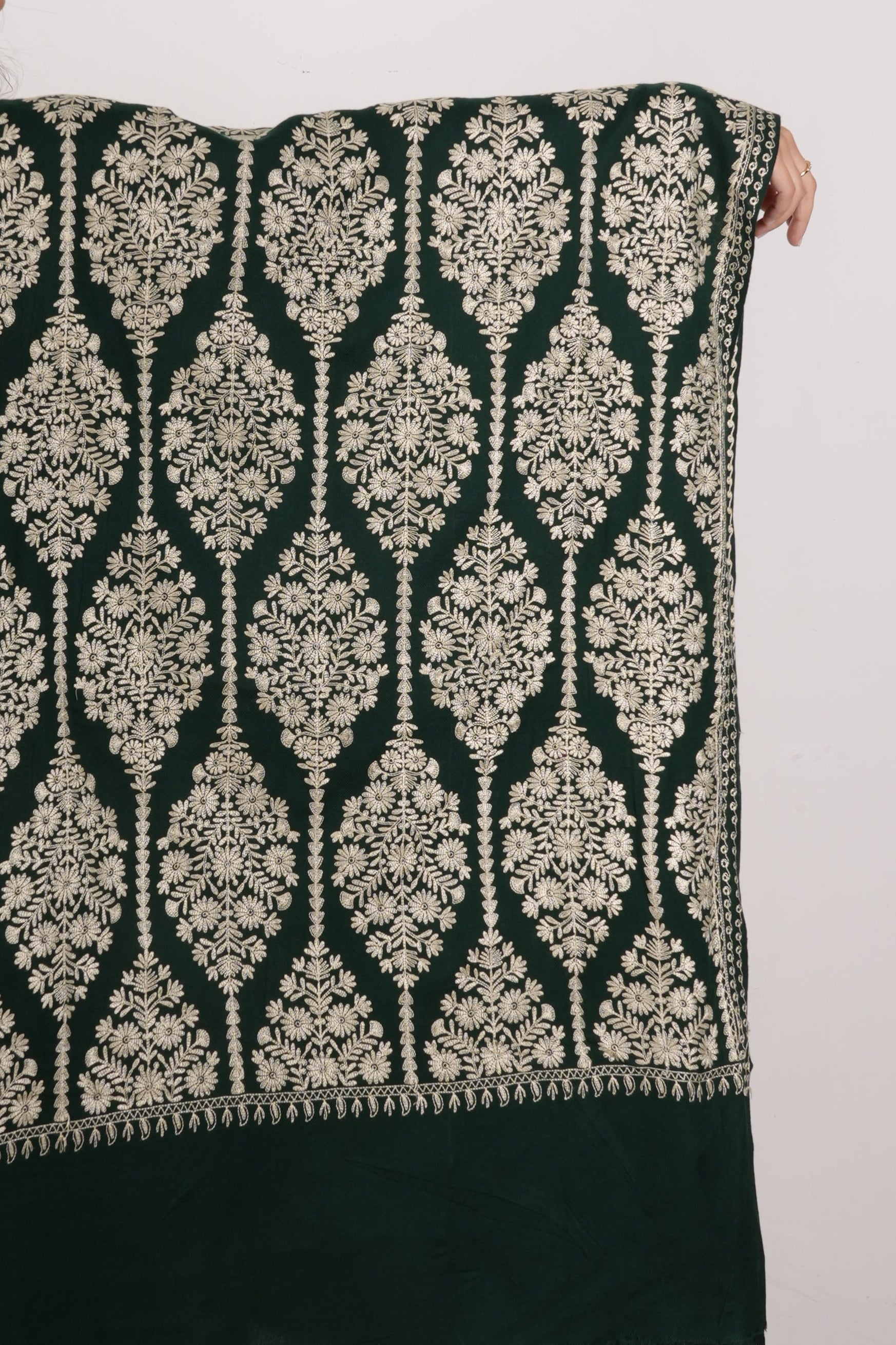 Person holding a green and white patterned fabric against a plain background